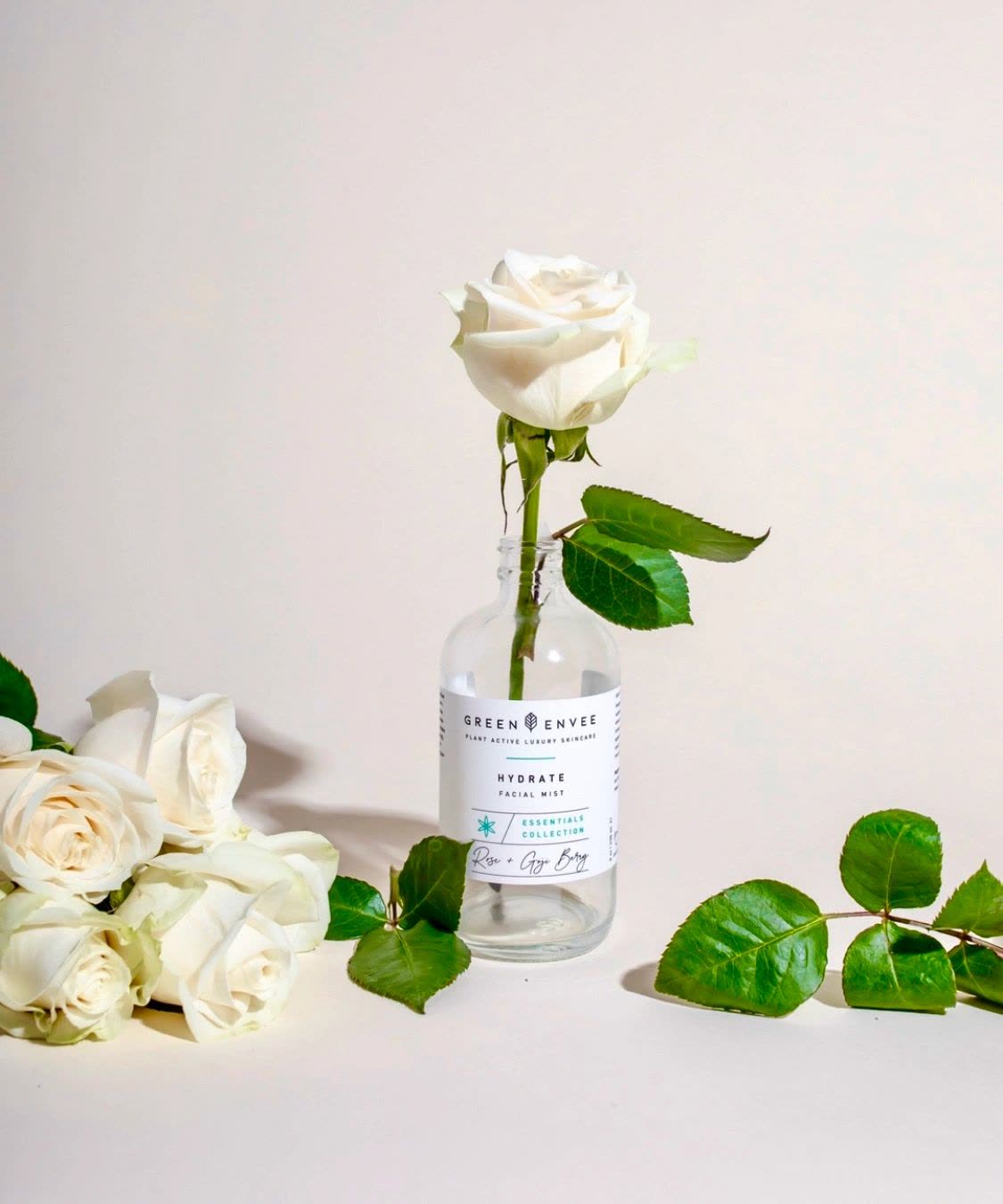 Green Envee bottle with white roses